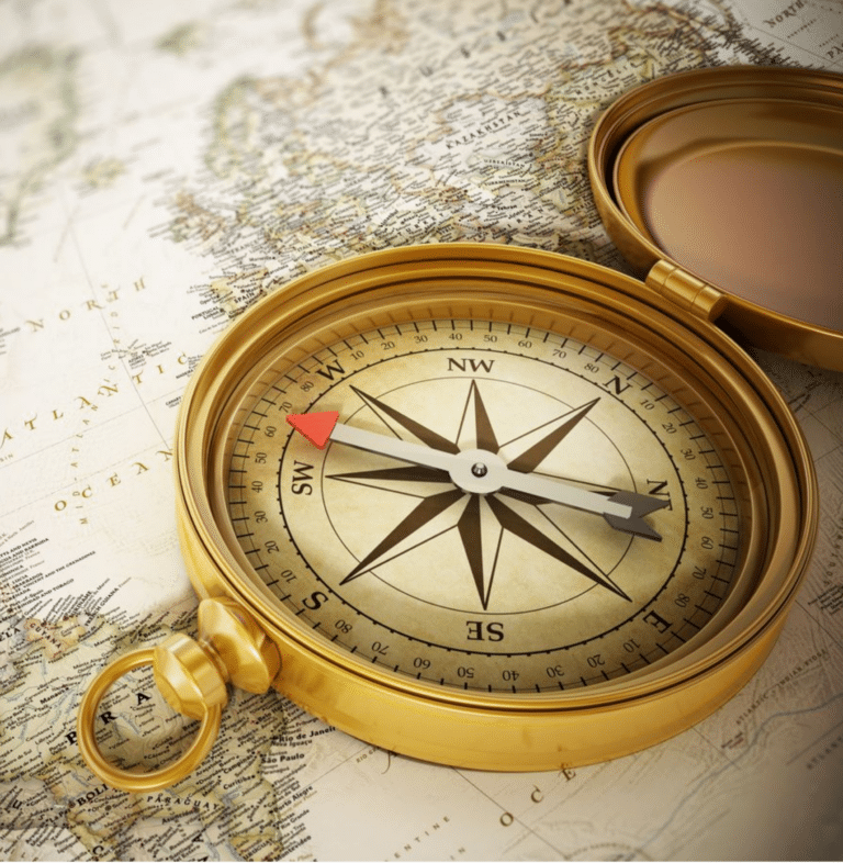 Close-up of a premium gold directional compass open on an antique world map, symbolising strategic career guidance and pathways.